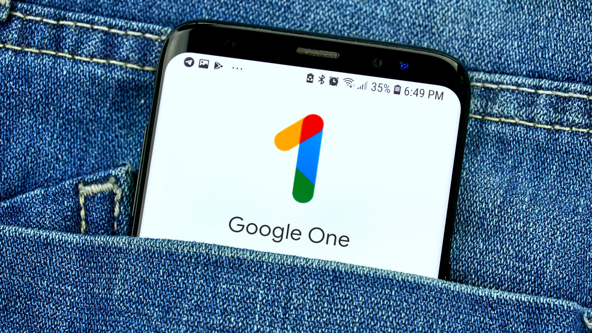 google one on smartphone screen in demin pocket.