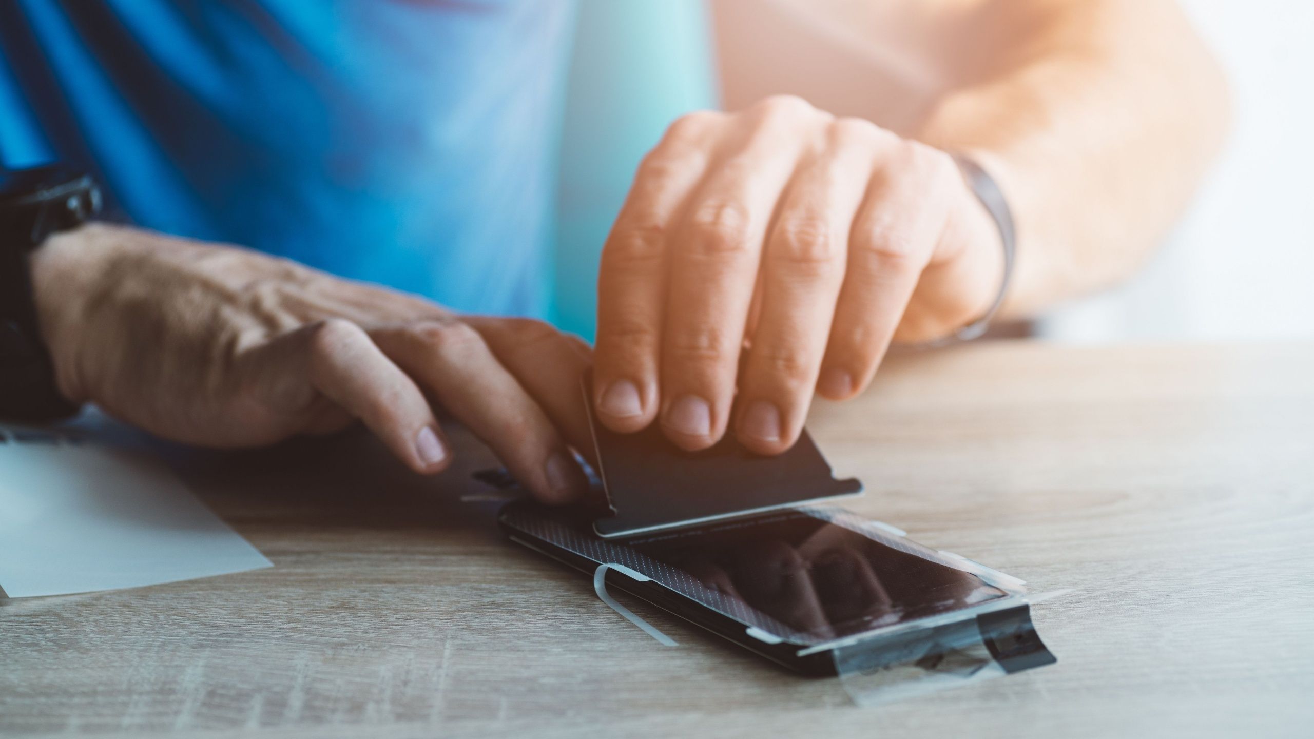 Man Applying Screen Protector on Phone