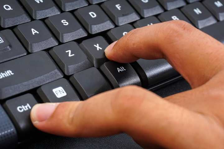 Fingers pressing keys on a PC keyboard