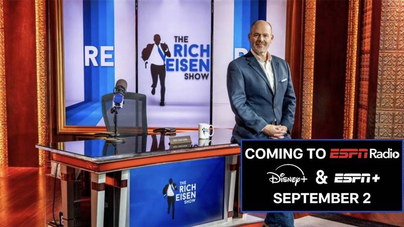 Rich Eisen on the set of “The Rich Eisen Show” with a banner announcing its debut on ESPN Radio, Disney+, and ESPN+.