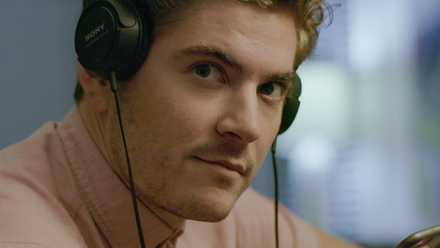 A man wearing headphones looks toward the camera, from HBO’s Murder on Middle Beach.