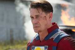 John Cena as Peacemaker in costume with blood on his face