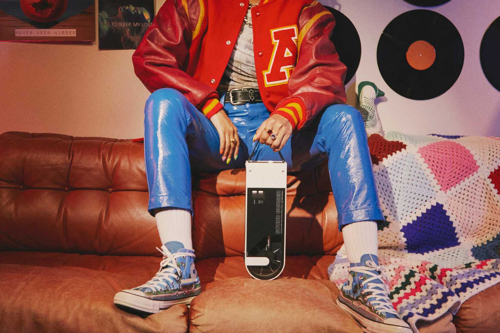 The legs of a young woman holding the Audio Technica Sound Burger turntable.