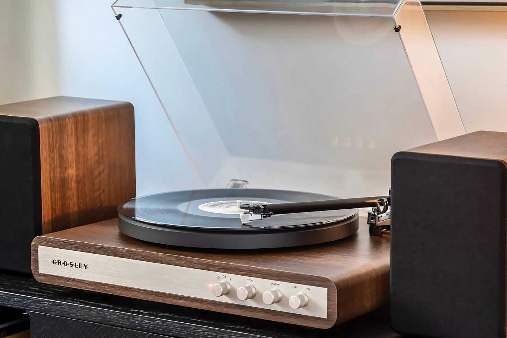 The Crosley C65 record player on furniture with desktop speakers.