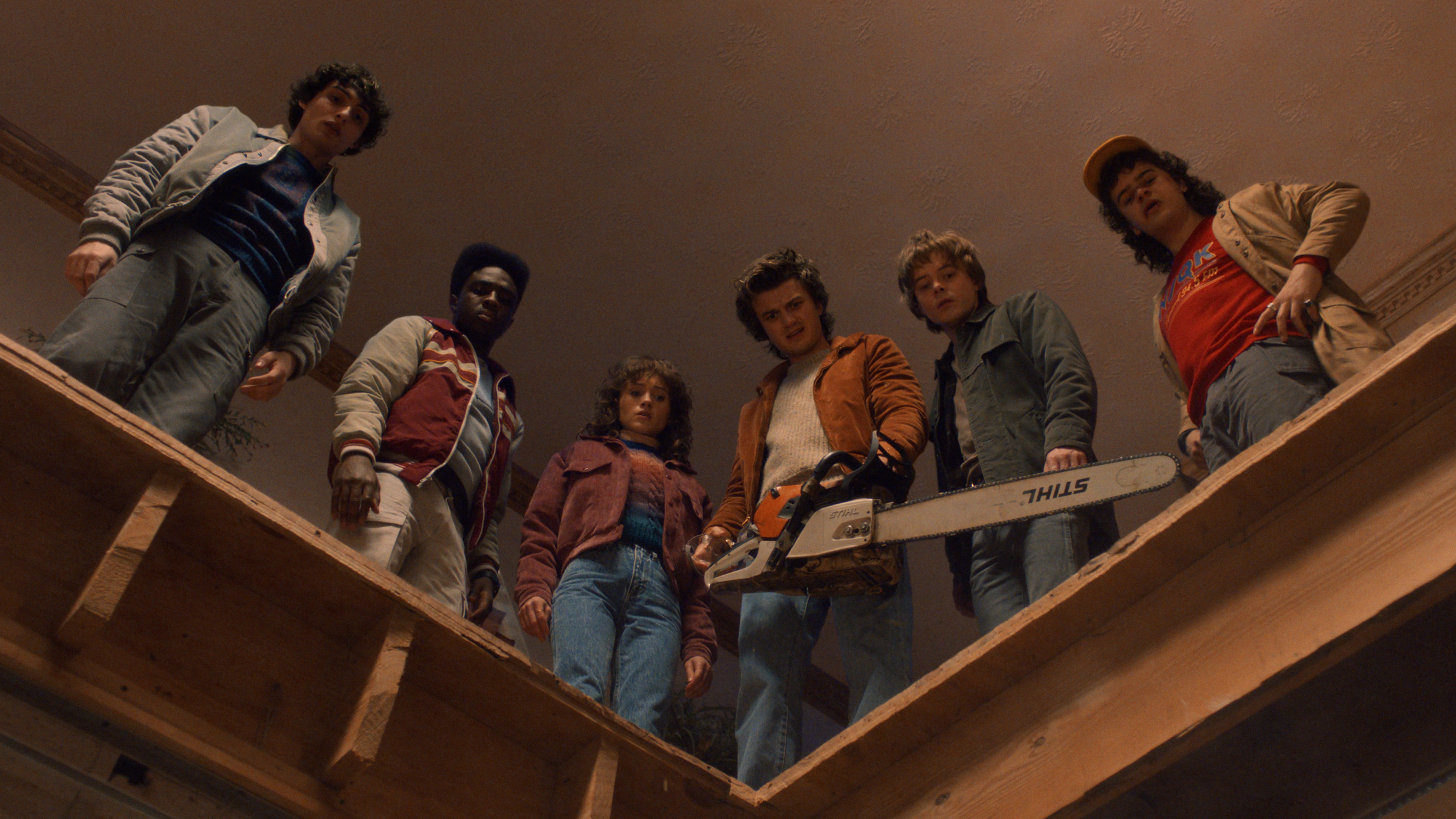 Mike, Lucas, Nancy, Steve, Jonathan, and Dustin in Stranger Things season 5, seen from below and Steve has a chainsaw