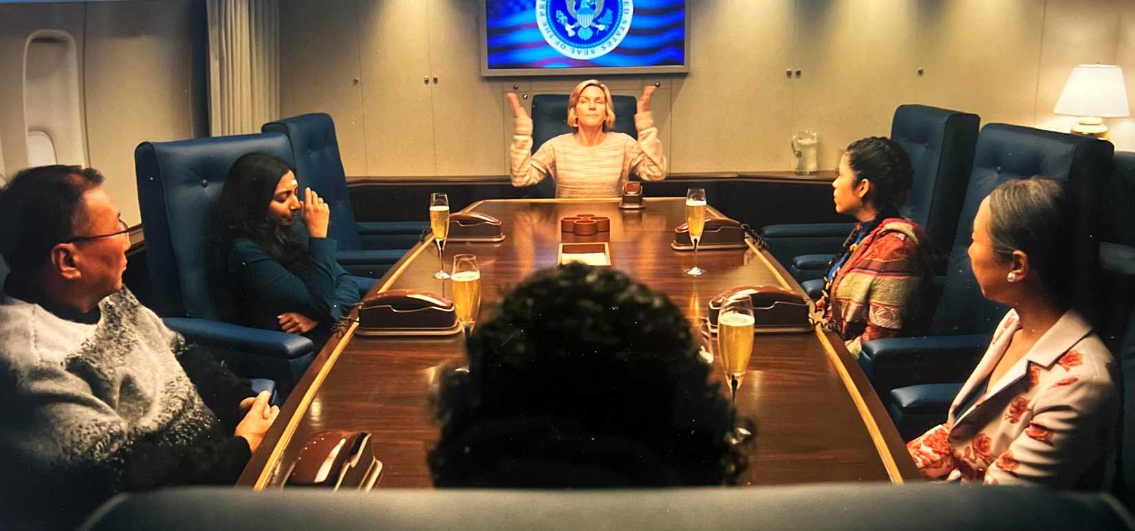 The survivors in Pluribus sitting at a table on Air Force One.