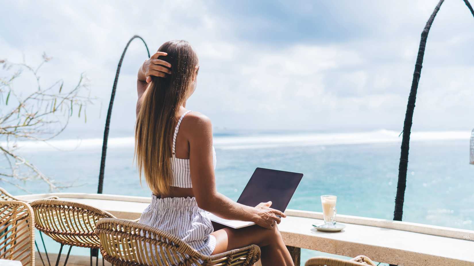 yesim woman using her laptop near the ocean