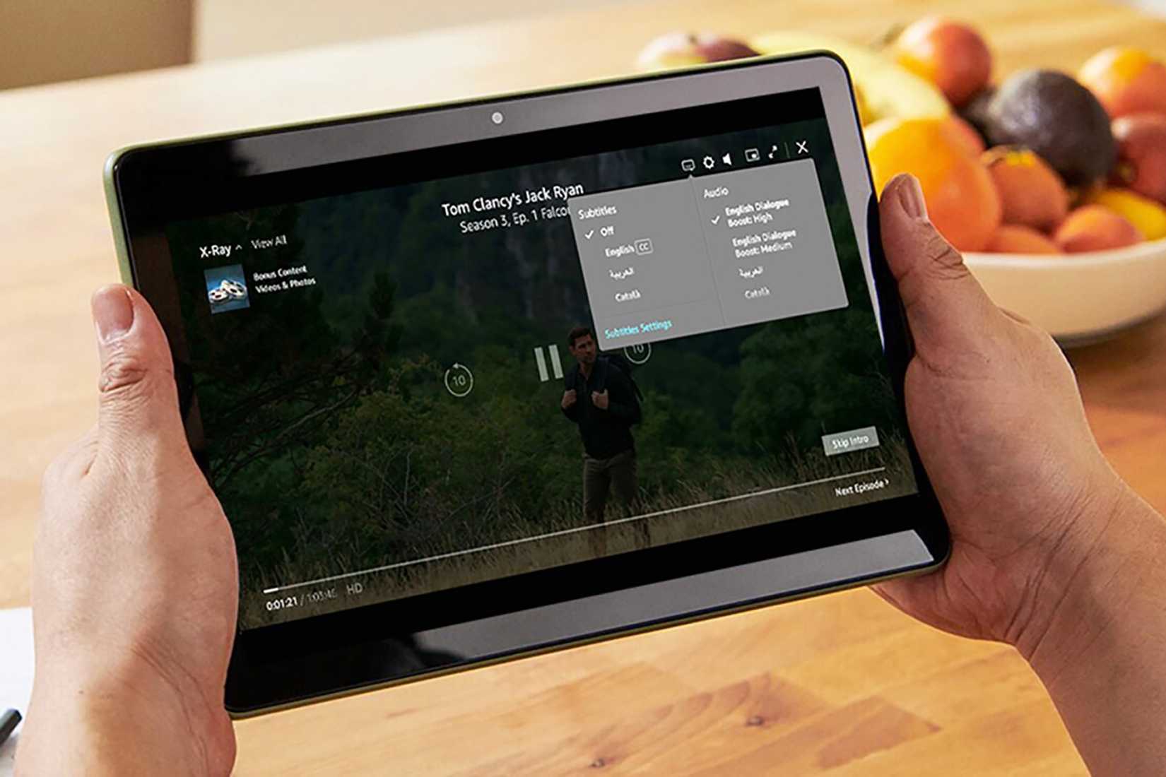 Two hands holding a tablet showing the Amazon Prime Video audio settings.