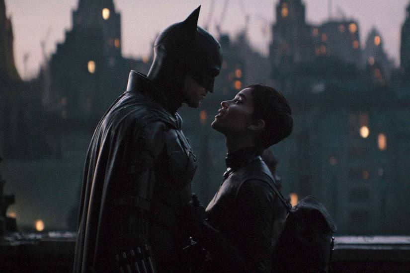 Batman and Catwoman standing in front of each other.