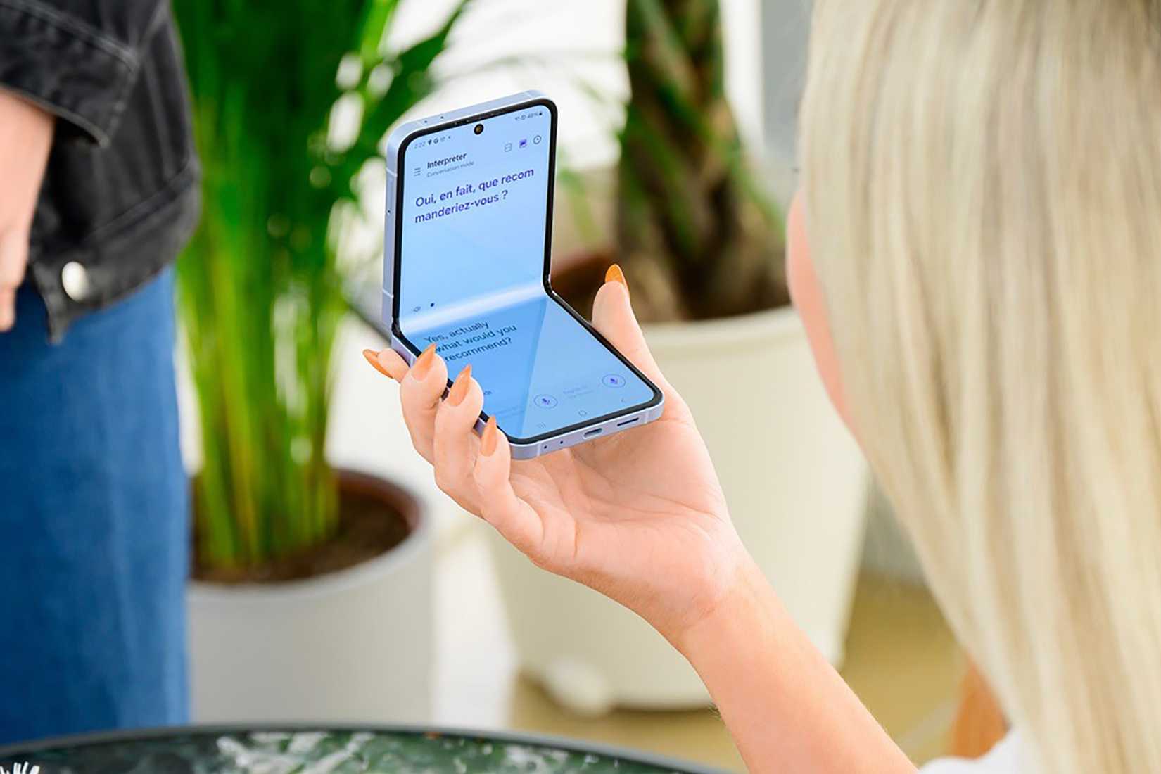 A woman holding a Samsung Galaxy Z Flip 7 using Interpreter.