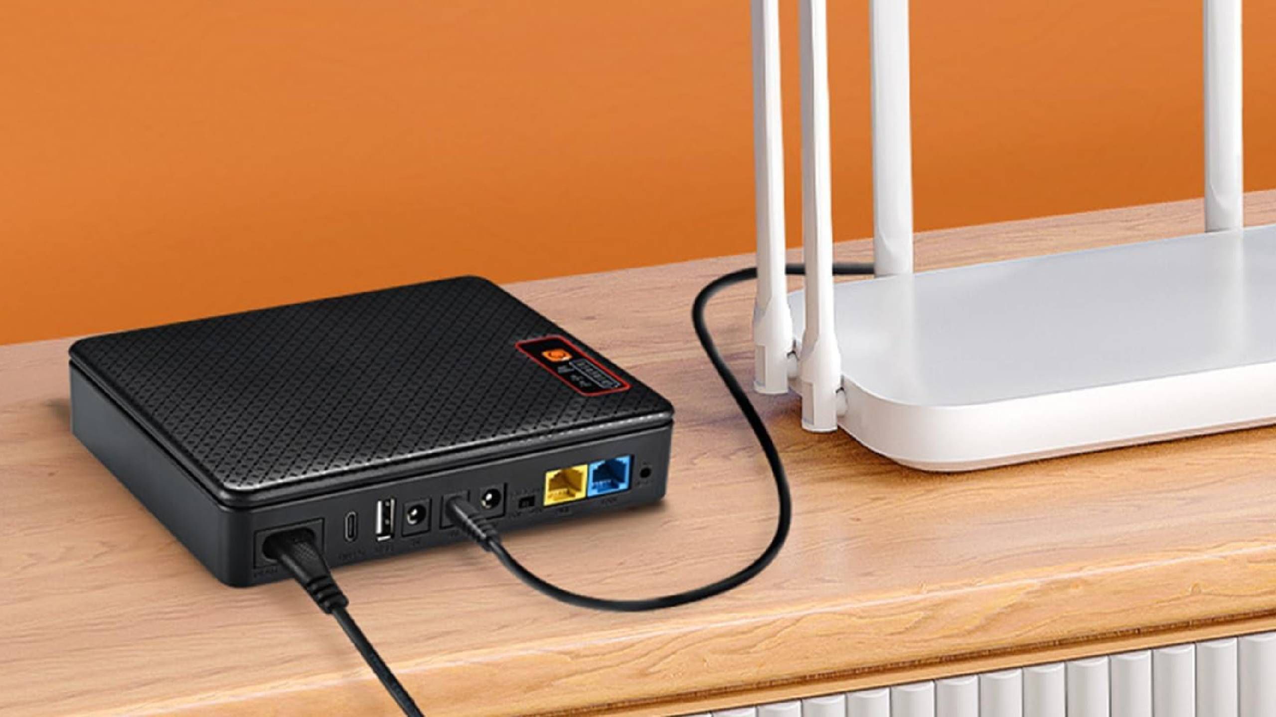 Yuuki mini dc UPS plugged into a router on a ledge