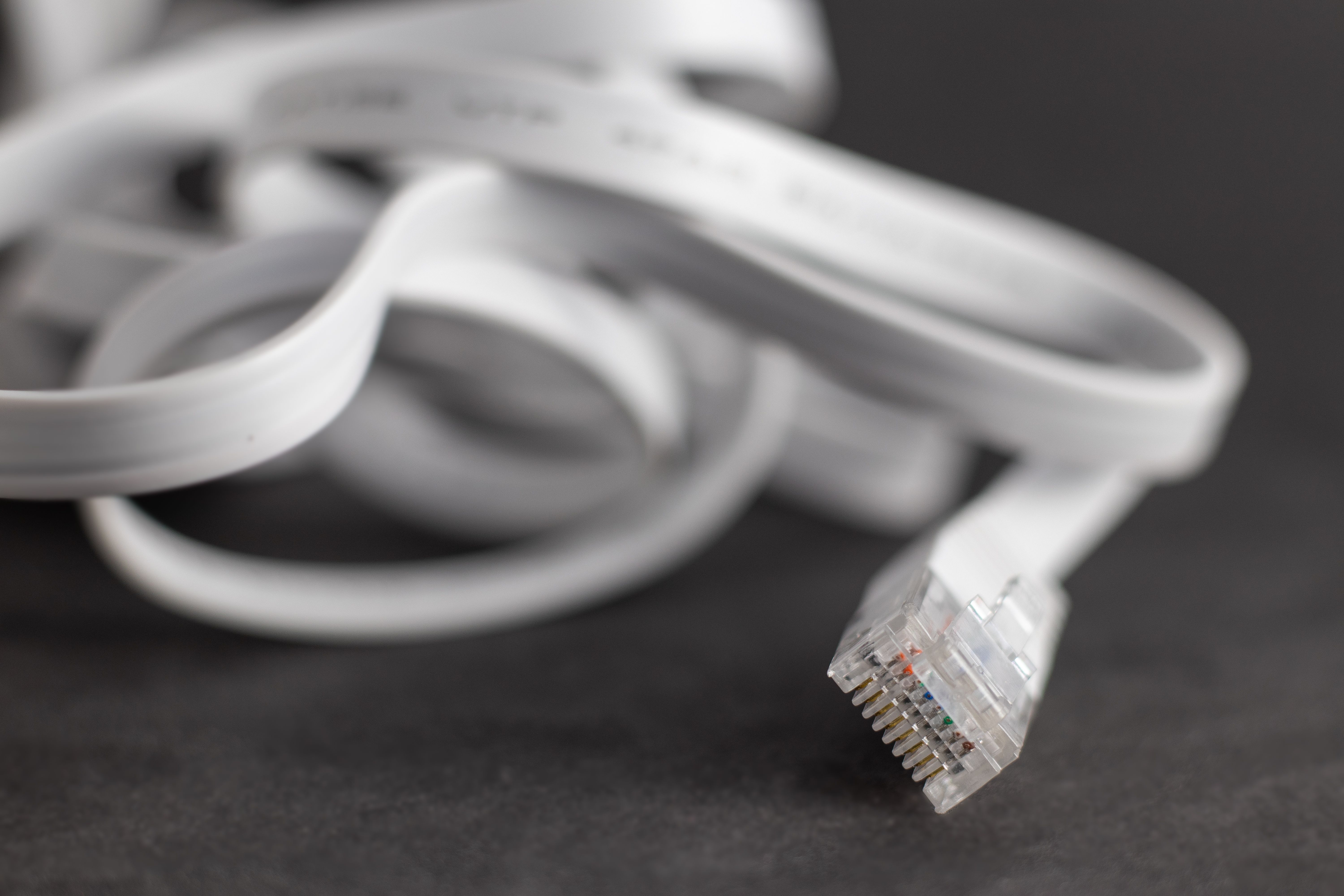 Flat ethernet cable lying on a desk.