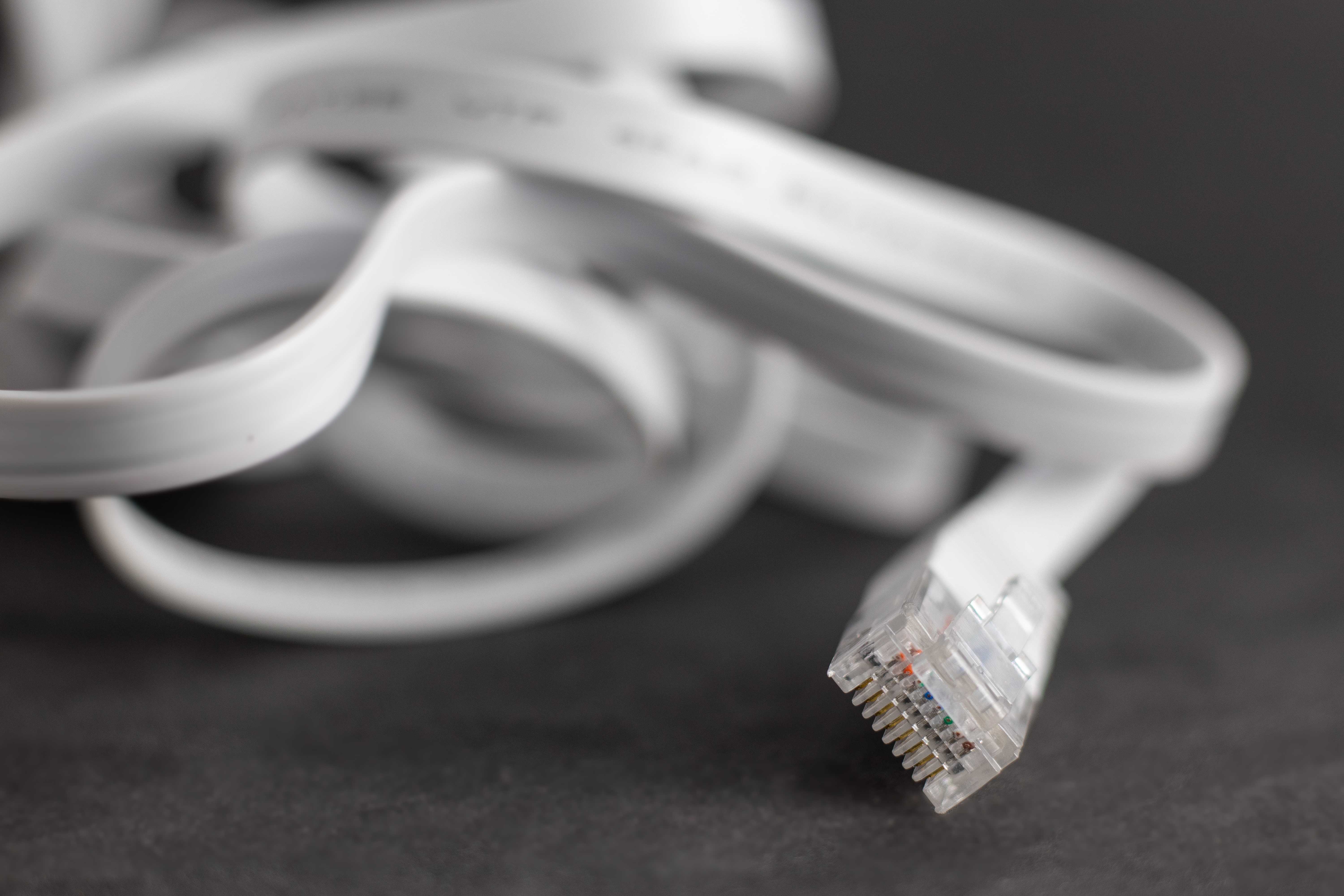 Flat ethernet cable lying on a desk.