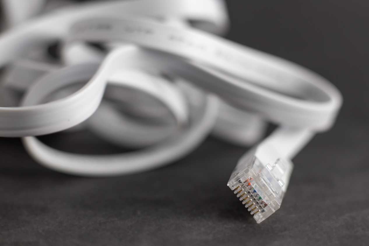 Flat ethernet cable lying on a desk.