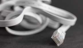 Flat ethernet cable lying on a desk.