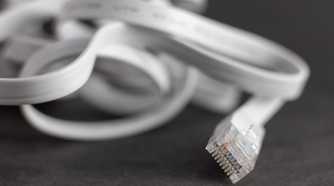 Flat ethernet cable lying on a desk.