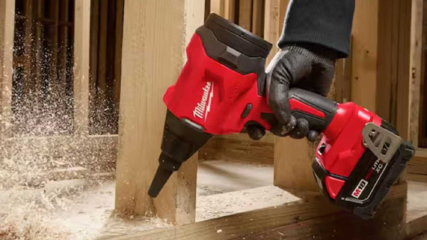 A Milwaukee M18 18V Lithium-Ion 570 MPH Brushless Cordless Precision Blower blowing sawdust