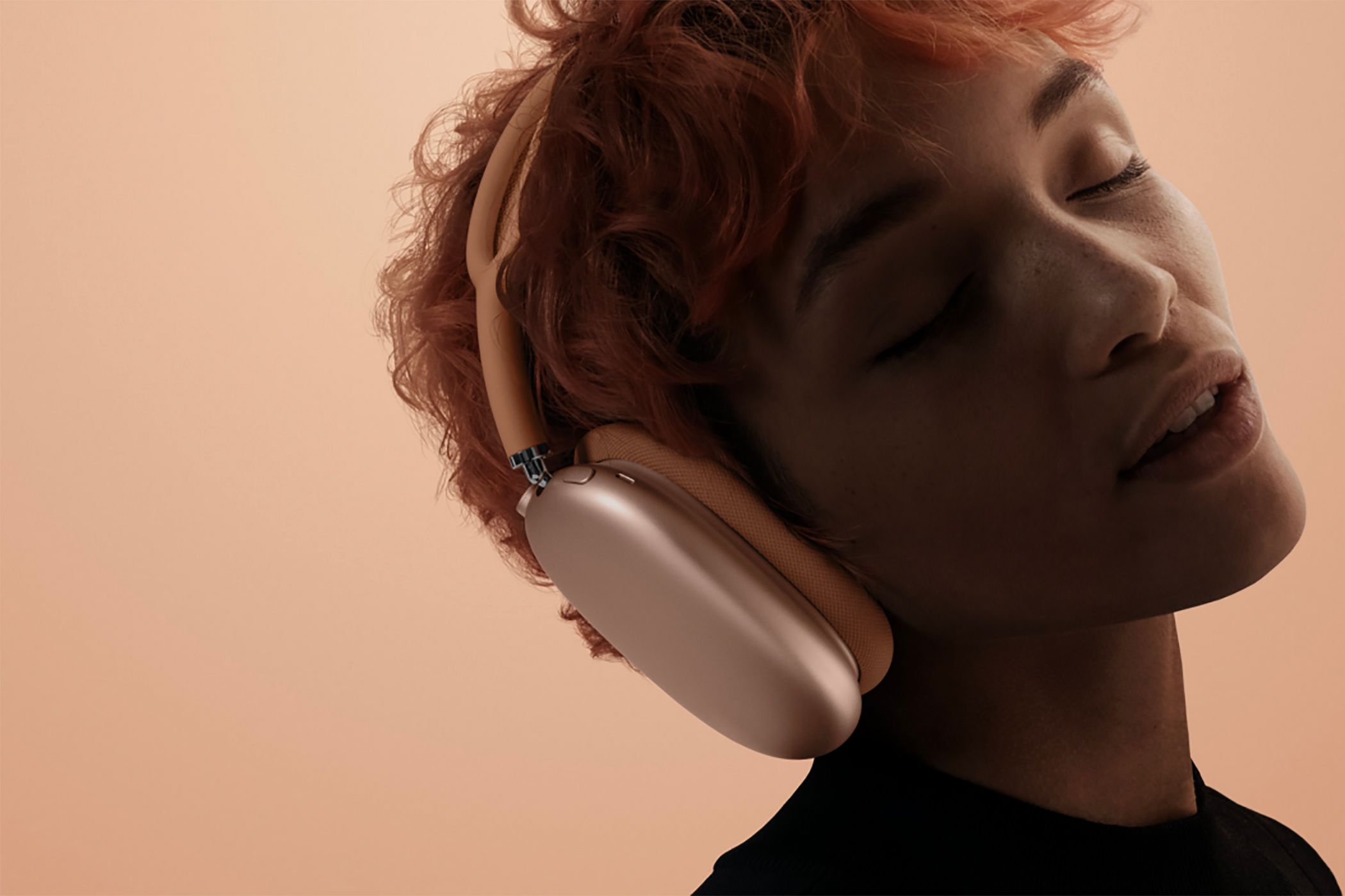 A woman with her eyes closed wearing the Apple AirPods Max 2. 
