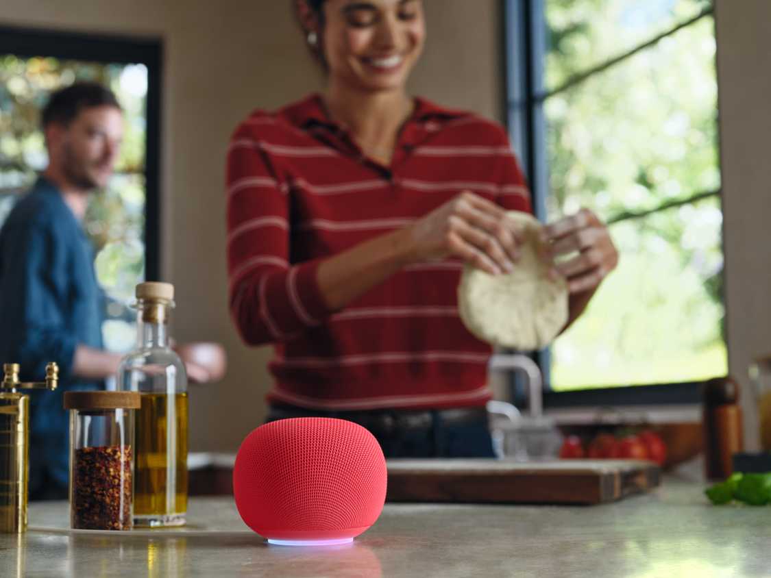 A Google Home Speaker in Berry, sitting on a kitchen counter.