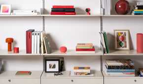 The Google Home Speaker in Berry sitting on a shelf.