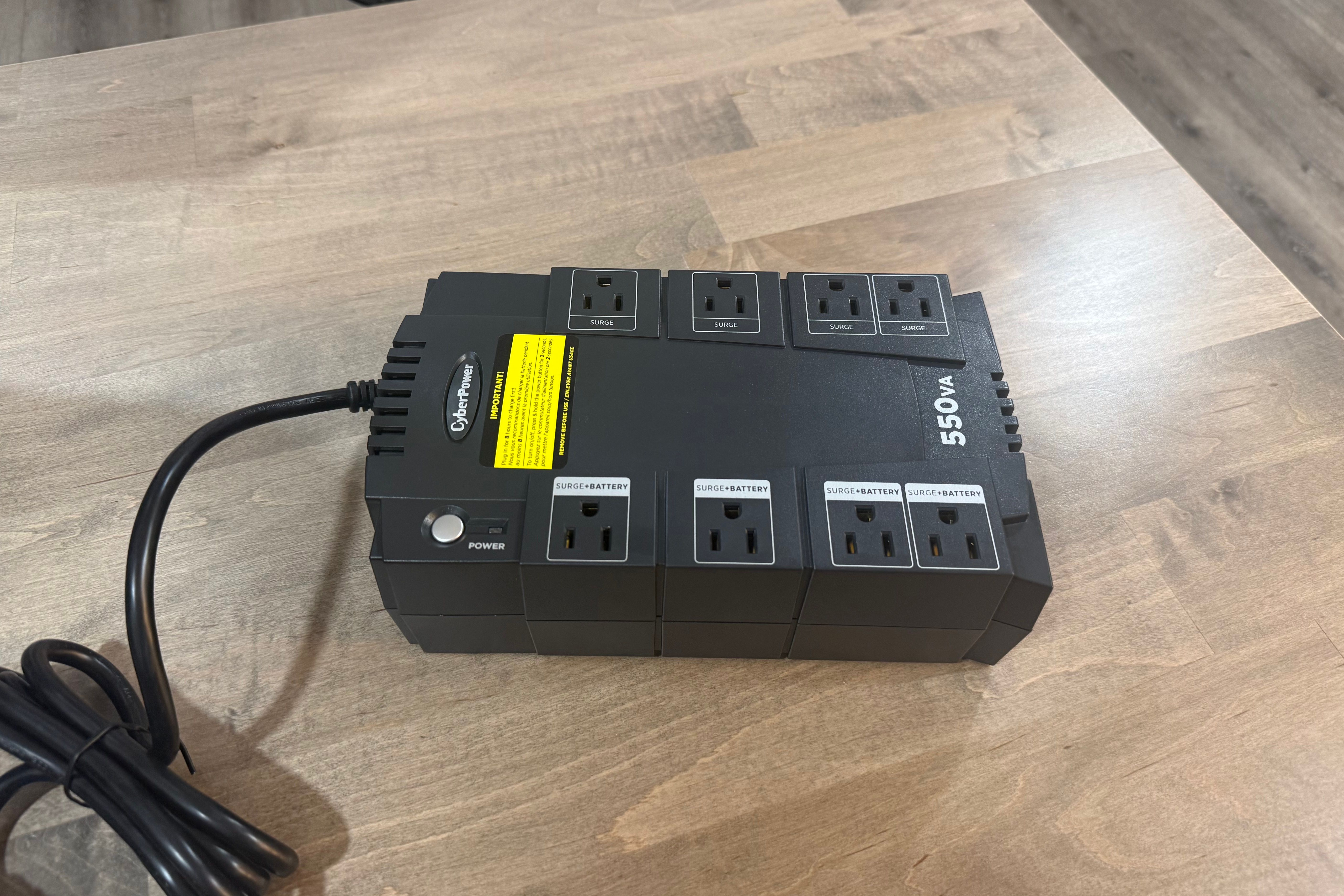 CyberPower 550VA UPS front angle view on wood desk