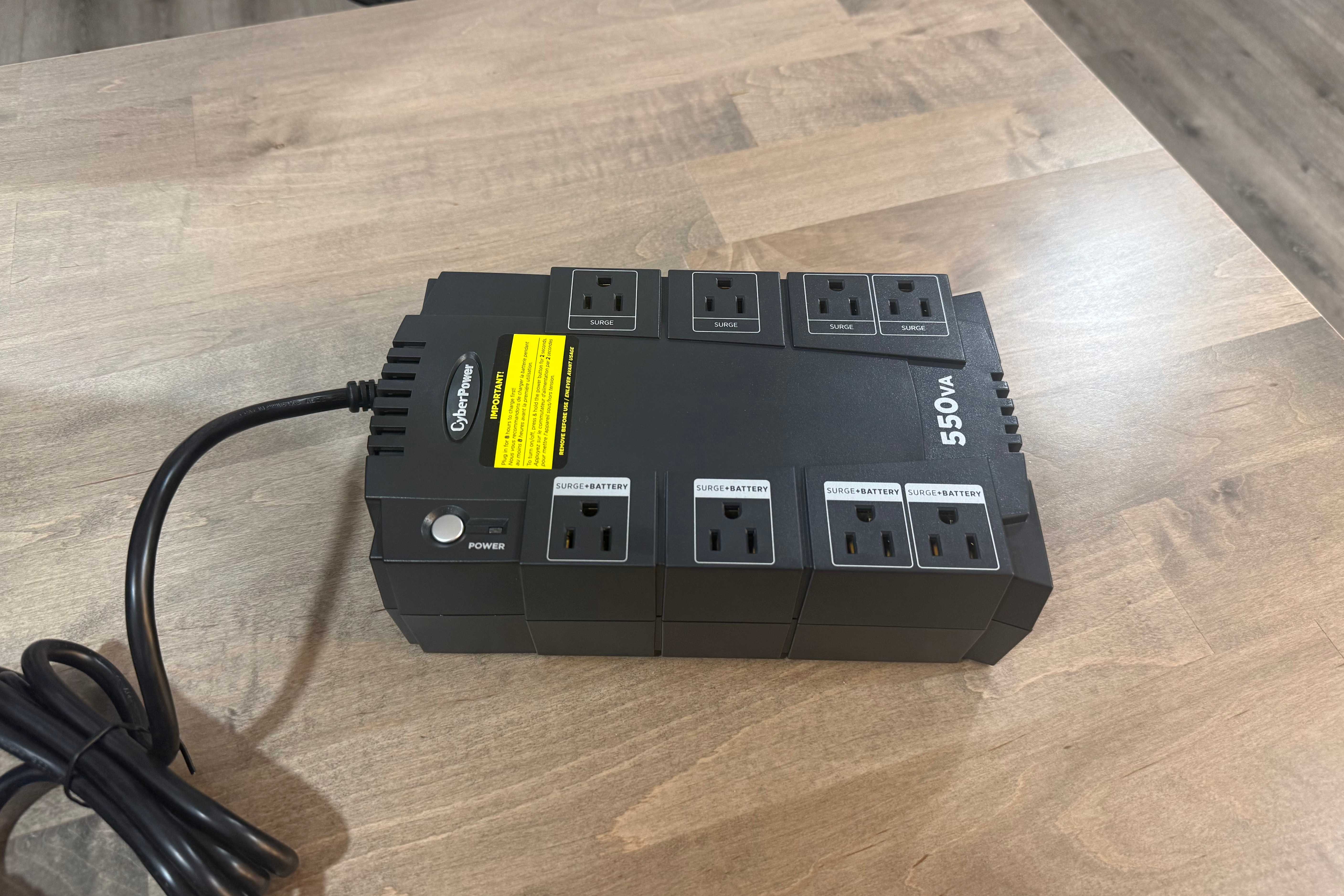 CyberPower 550VA UPS front angle view on wood desk