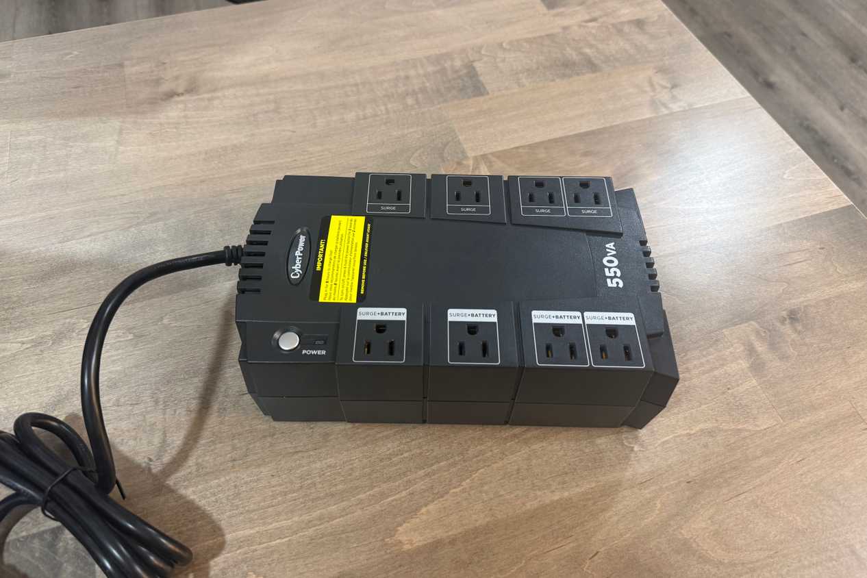 CyberPower 550VA UPS front angle view on wood desk