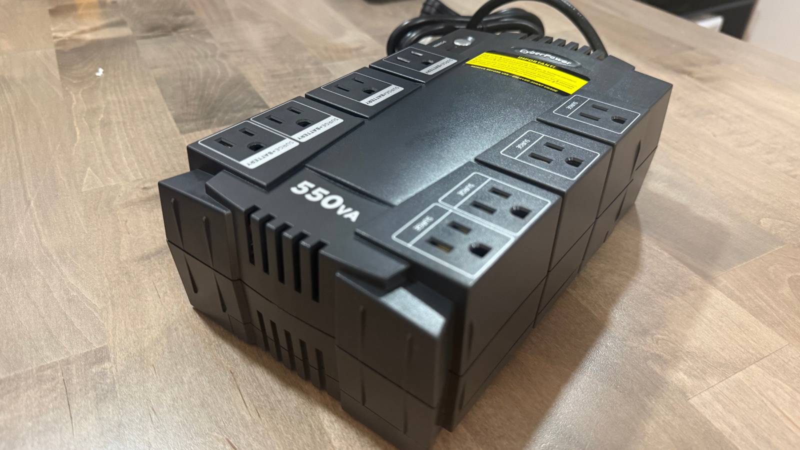 CyberPower 550VA UPS side angle showing branding on desk