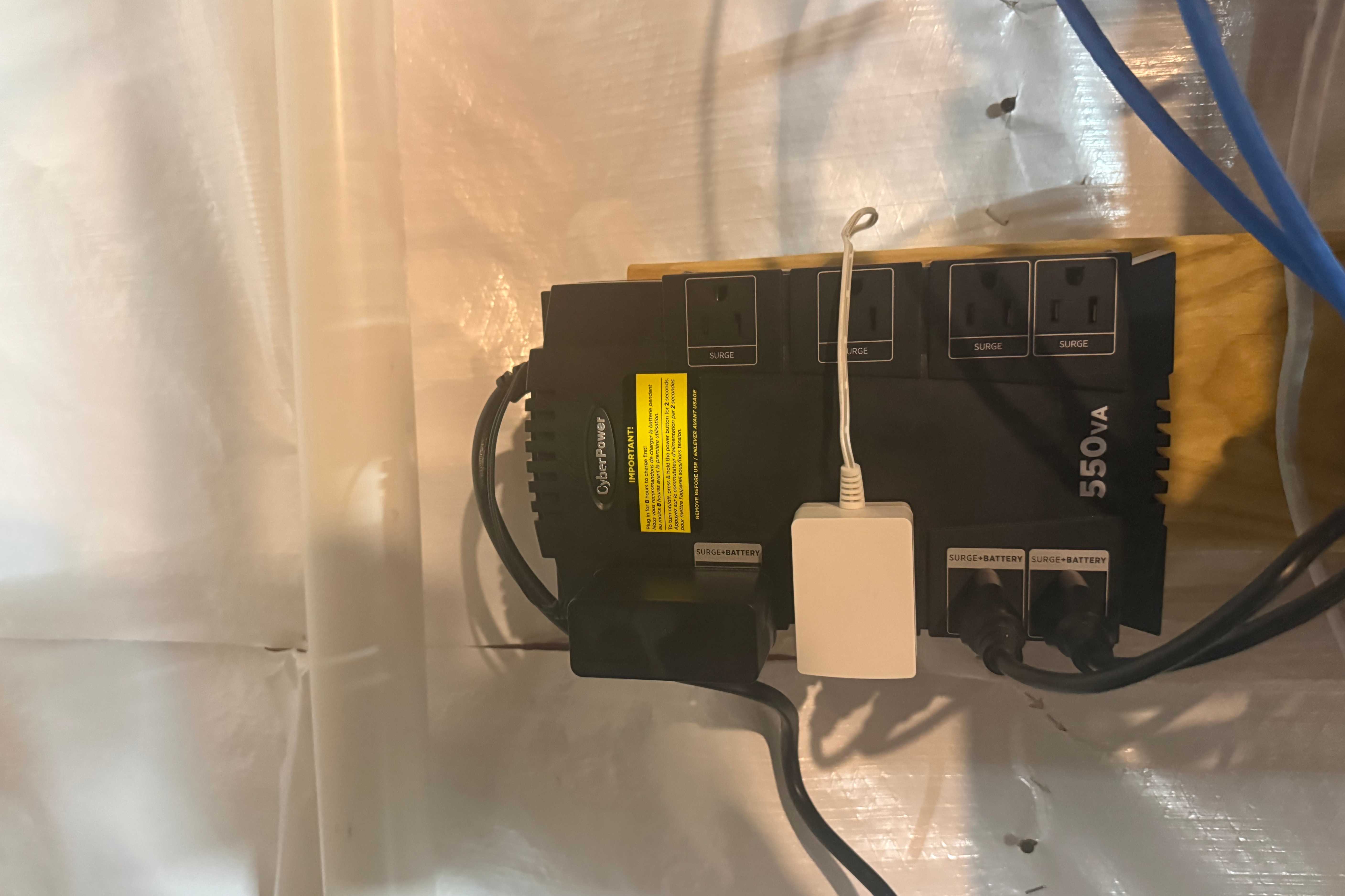 CyberPower 550VA UPS wall-mounted with outlets in use