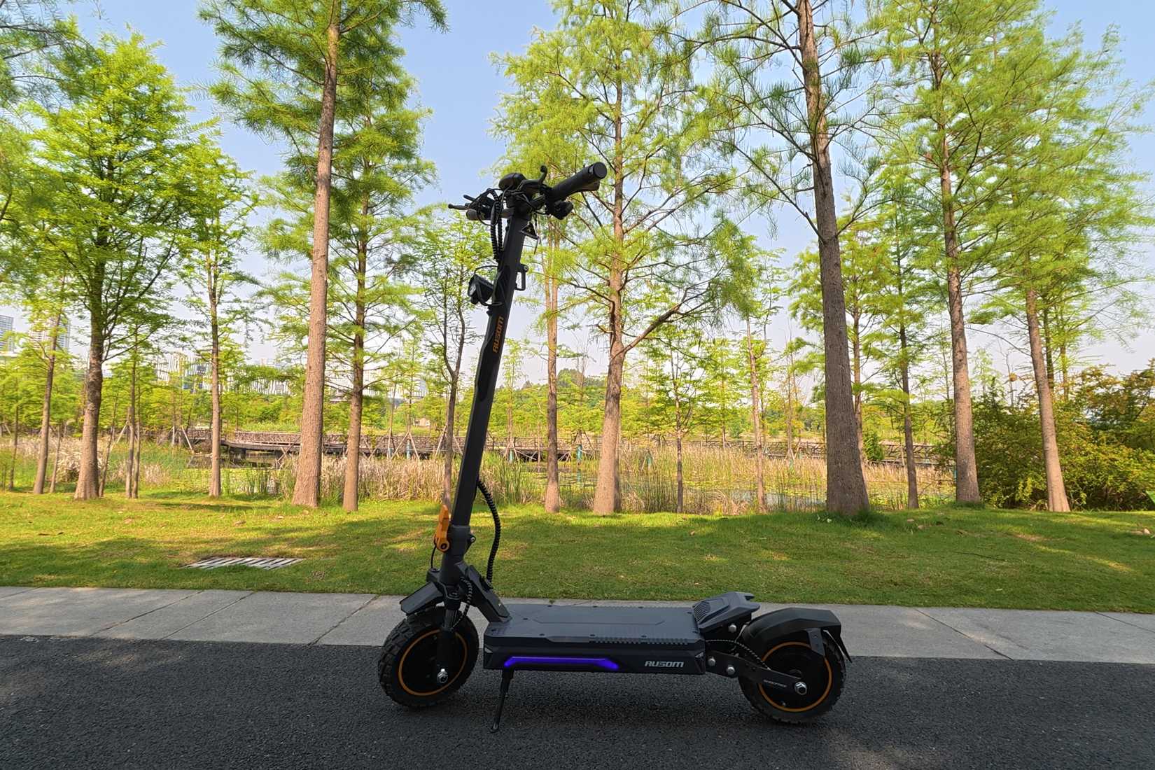 Side view of the Ausom K20 Pro Dual Motor with trees in the background