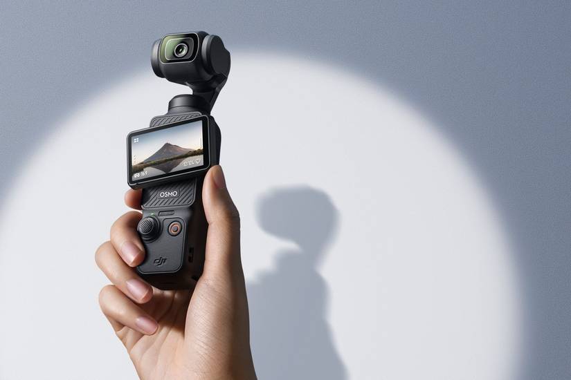 A hand holding the DJI Osmo Pocket 3 on a gradient background.
