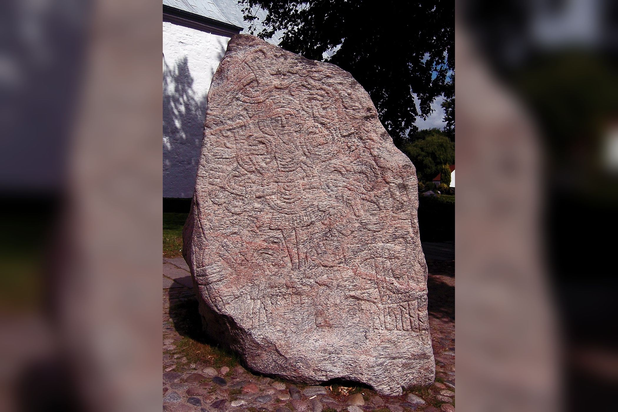 Ancient runestone standing outside a building