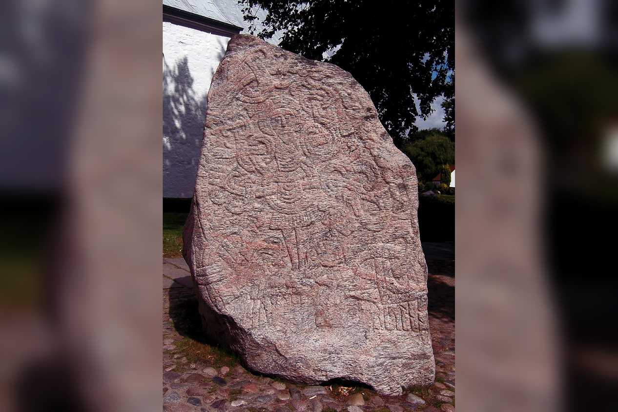Ancient runestone standing outside a building
