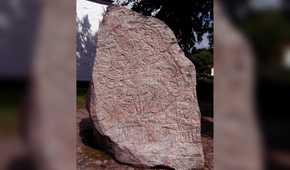 Ancient runestone standing outside a building