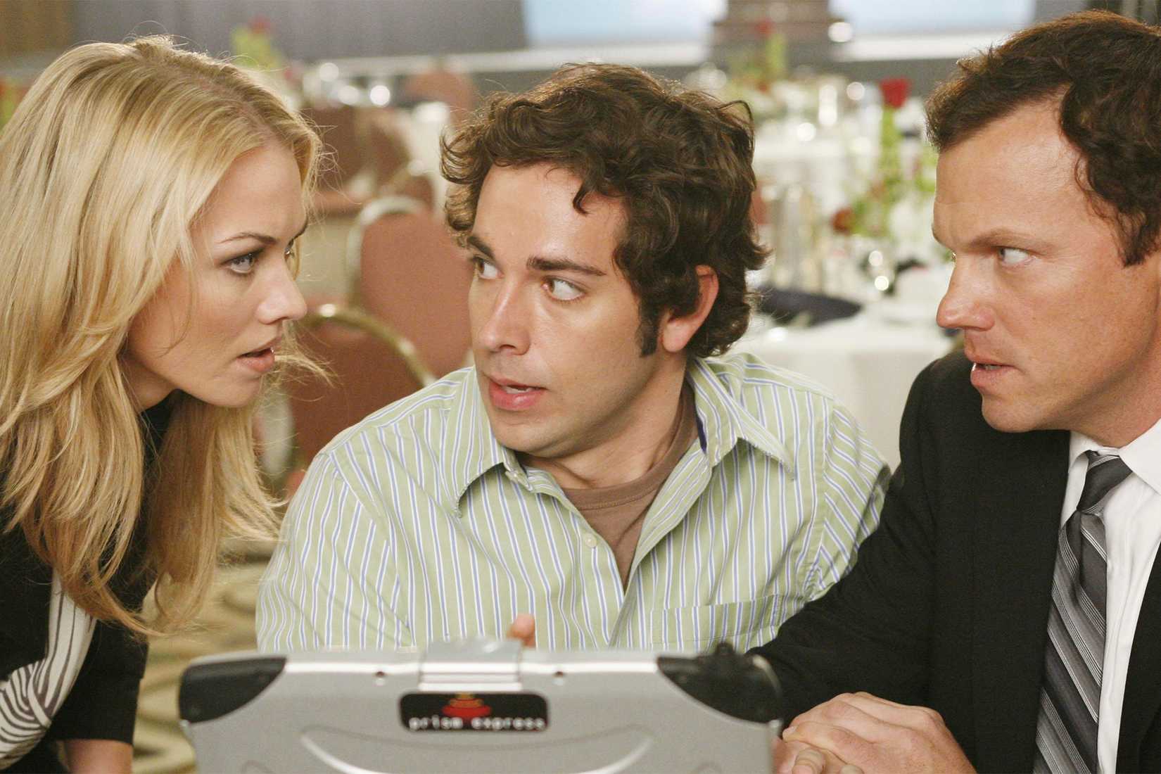 Two agents flank Chuck in the store as he looks at a computer in Chuck.