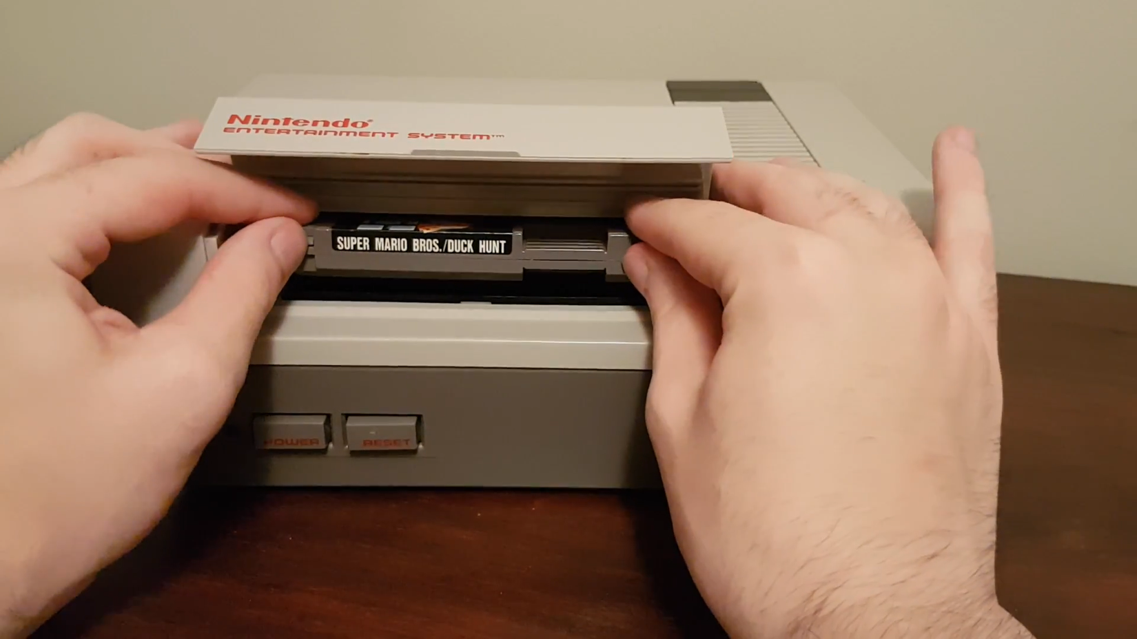 Inserting game cartridge into Nintendo Entertainment System