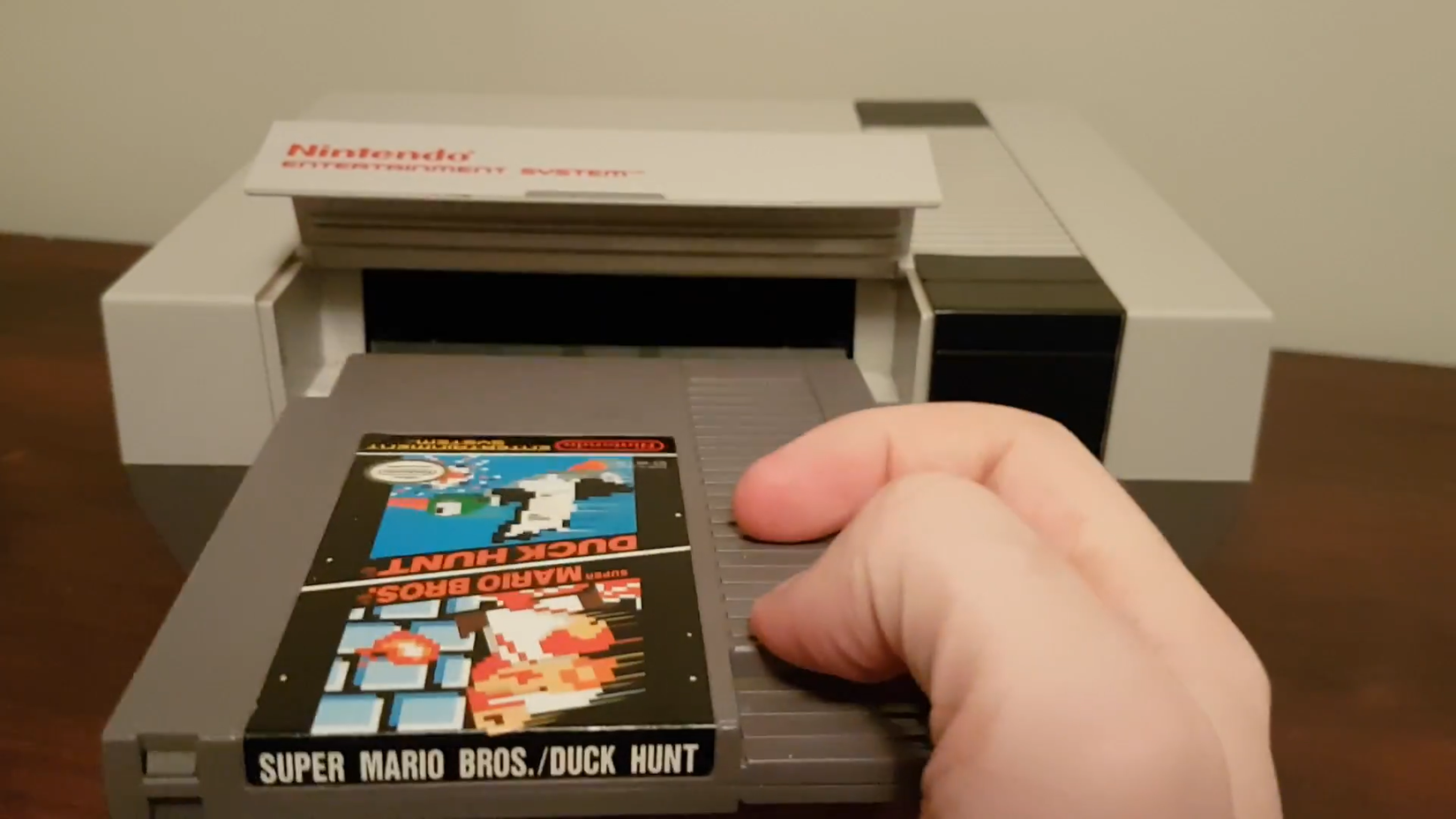 Inserting game cartridge into retro NES console