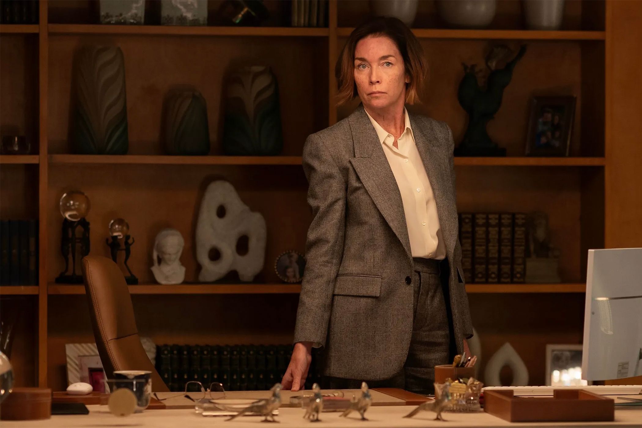 Sinatra standing behind her desk in Paradise.