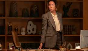 Sinatra standing behind her desk in Paradise.