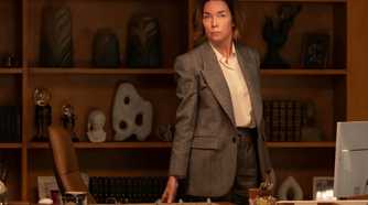 Sinatra standing behind her desk in Paradise.