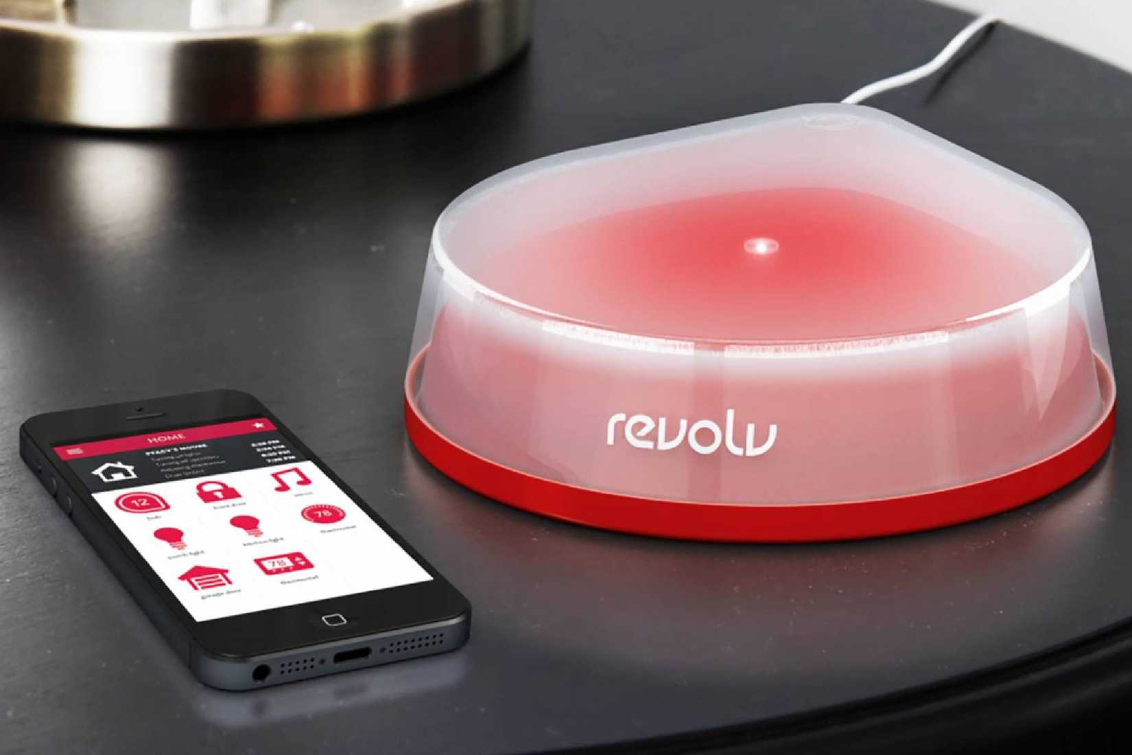 Revolv smart home hub with a phone next to it