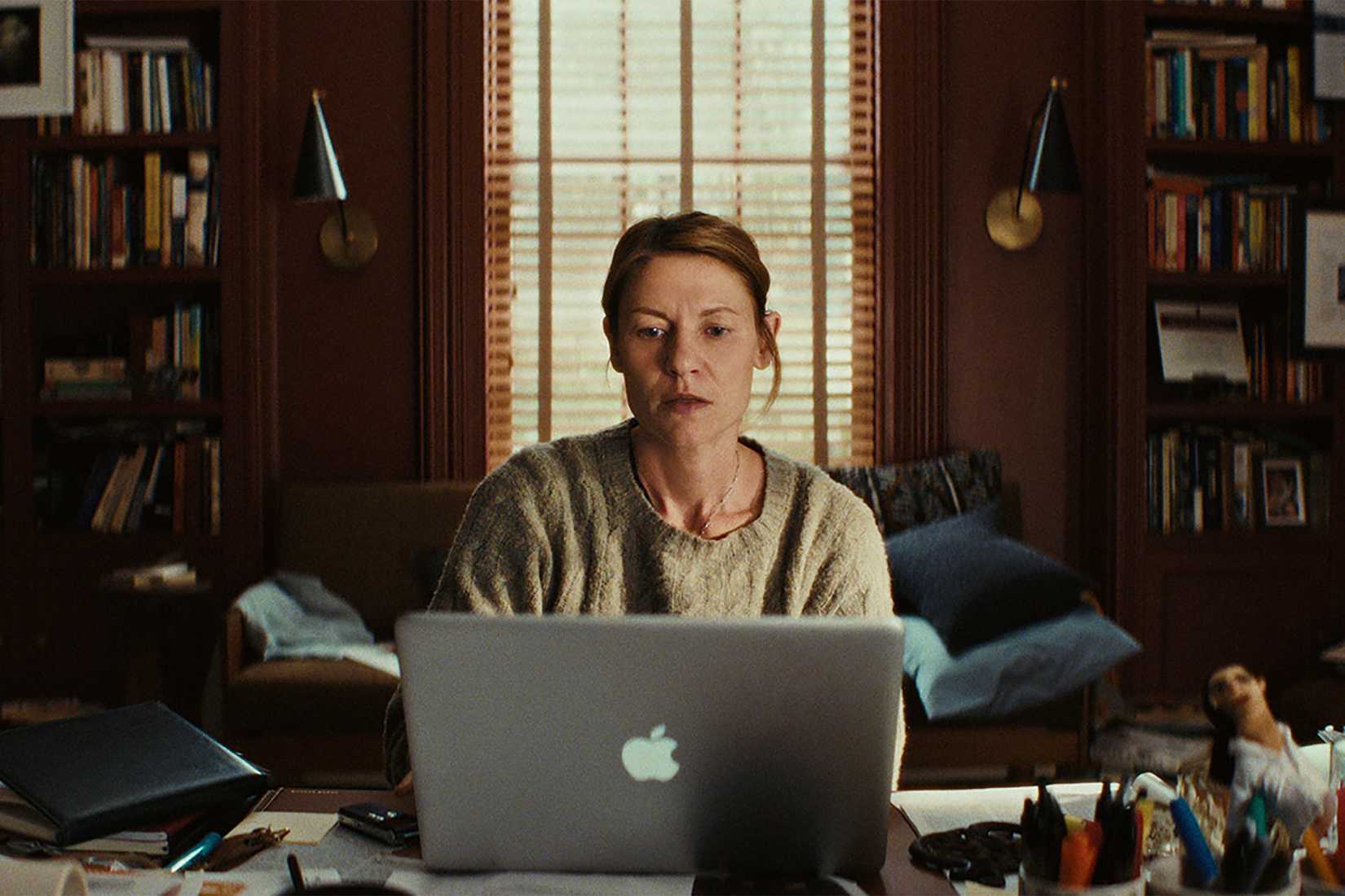 Aggie sitting at her desk staring at her computer in The Beast in Me.