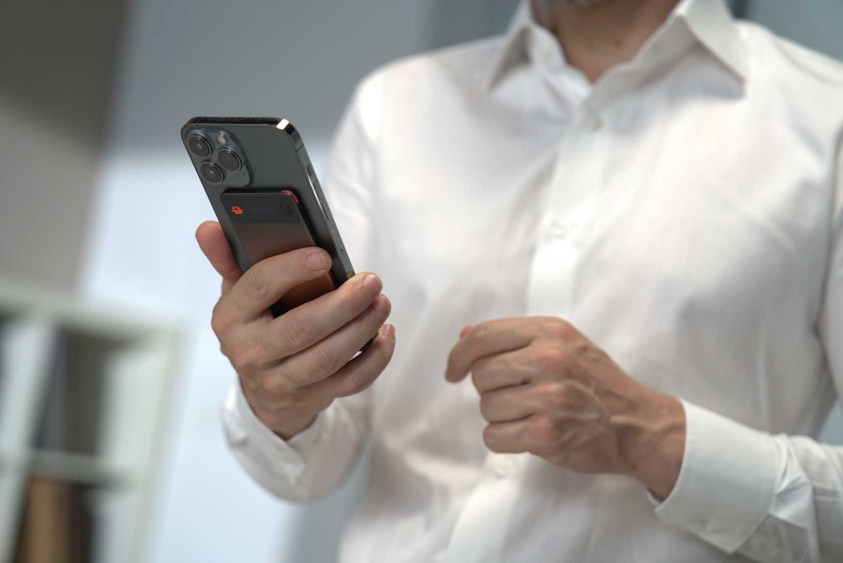 Man holding his phone with the EurekaMind 2.0 AI Note attached
