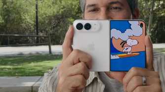 A man holding the iPhone Duo up with a Kid Cue Peanuts animation on the front screen.