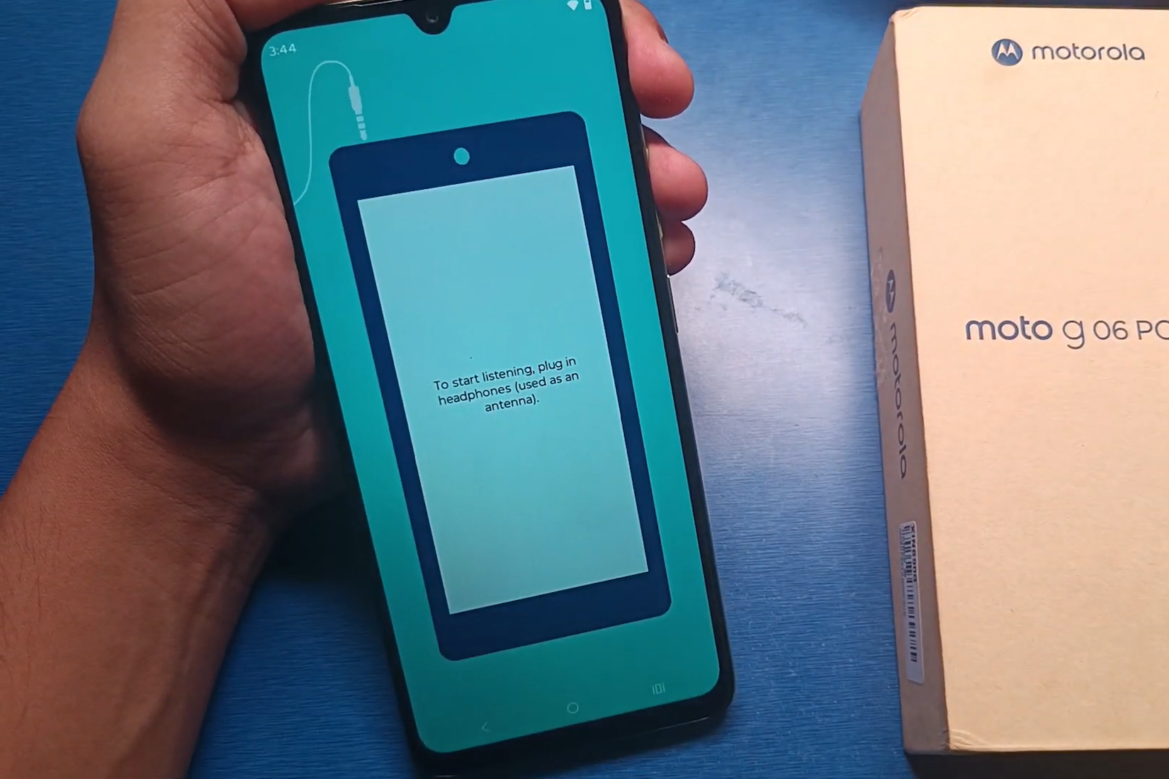 Motorola phone displaying headphone antenna prompt for FM radio.