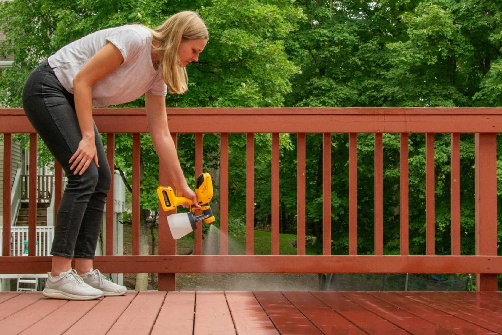 A woman using a Wagner Cordless Stain Sprayer