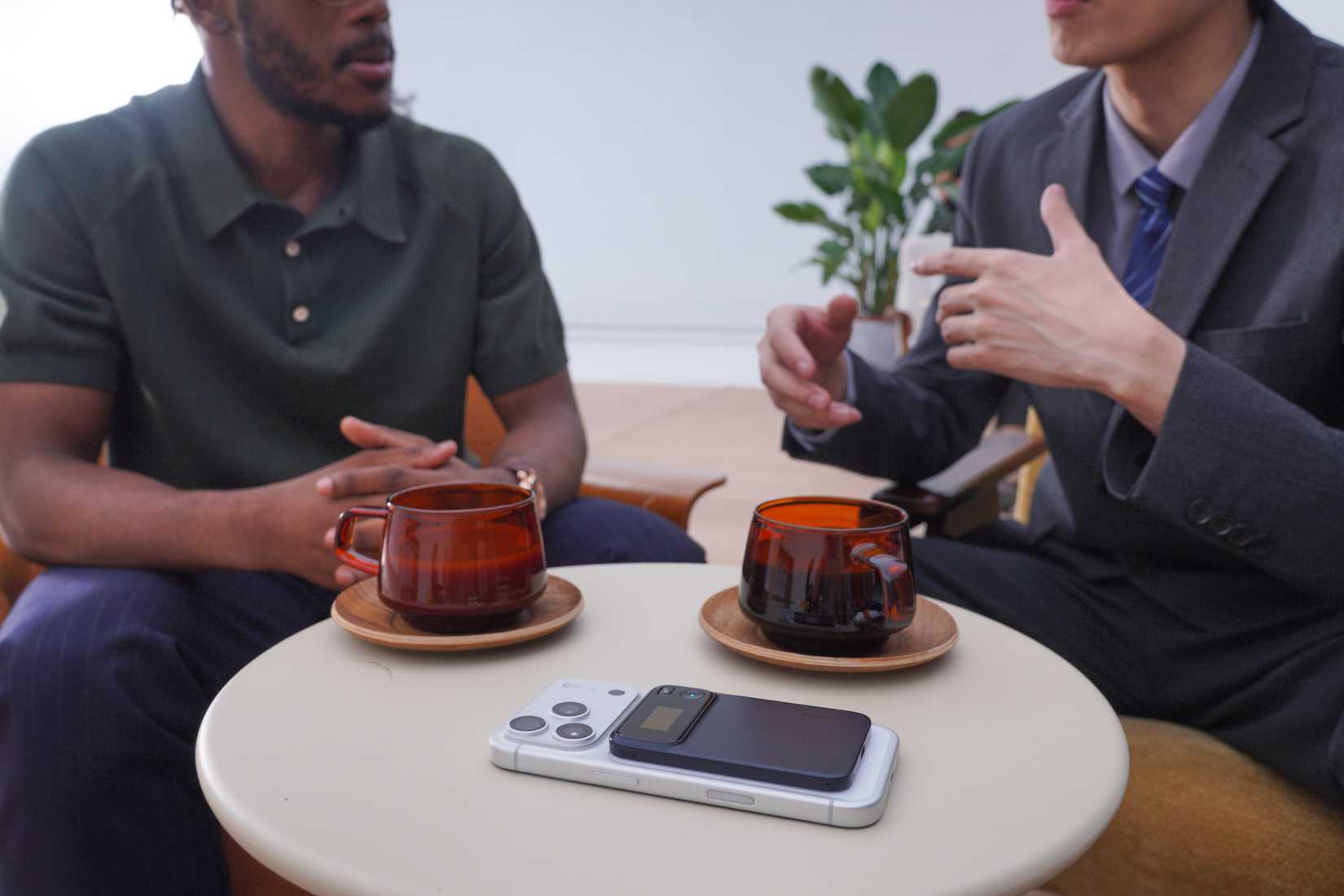 Men having a conversation over drinks with the Comu Action Pro recording from its placement on a phone.