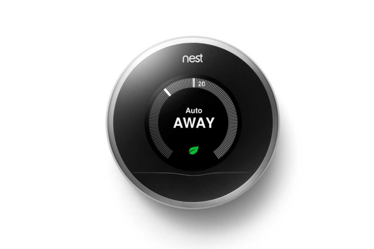 A first-generation Nest learning thermostat in a press image.