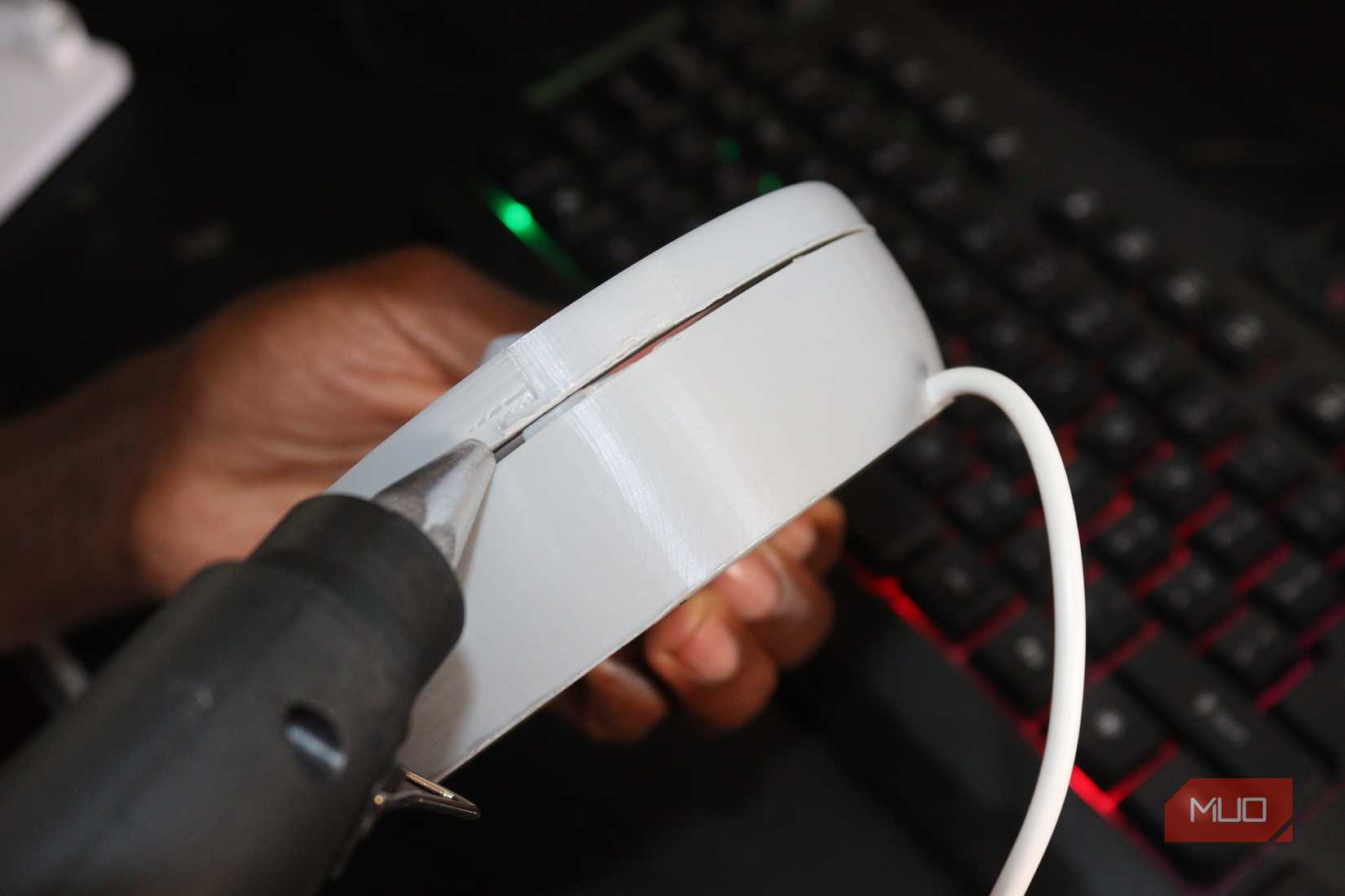 Using a glue gun to apply glue to the sides of a PC fan