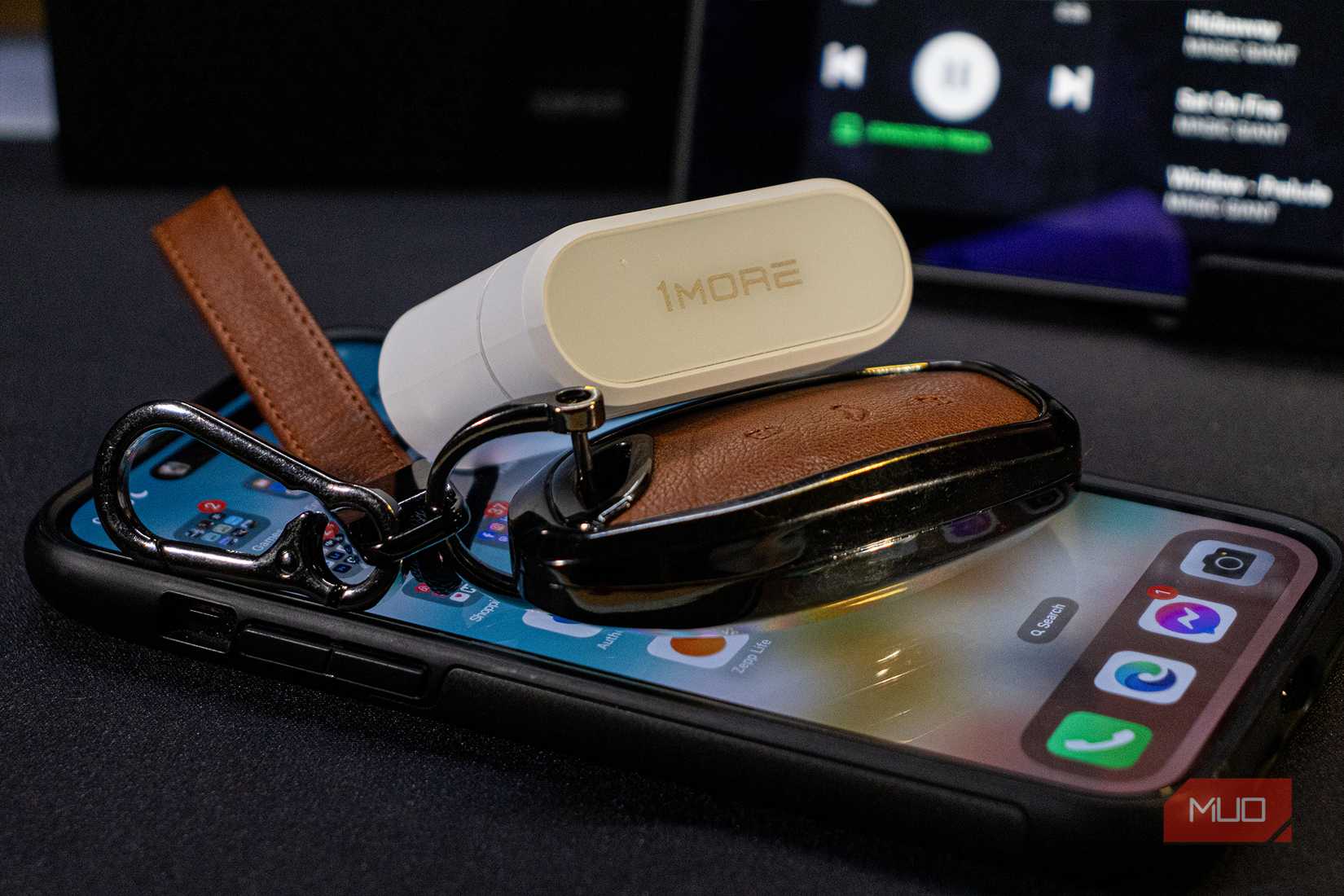 1More PistonBuds Pro Q30 on an iPhone 14 Pro Max and car keys for size reference
